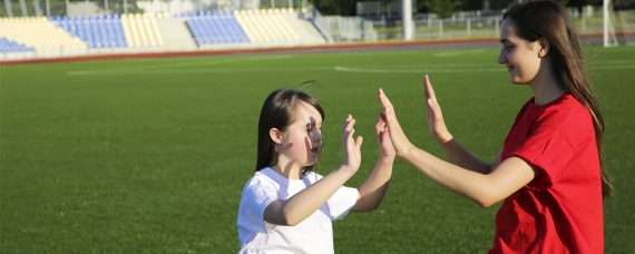 Teacher with a student at a sports field