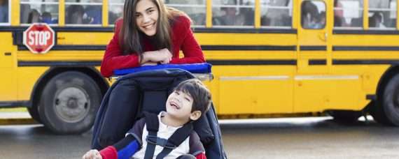 Teacher with a student waiting to get into the school bus.